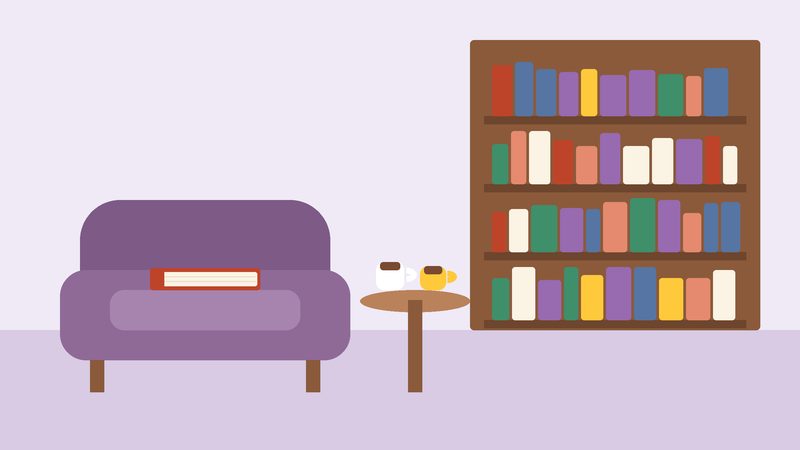 ركن قراءةٍ فيه مقعدٌ وثير وفنجانا شاي ورفٌّ عالٍ من الكتب