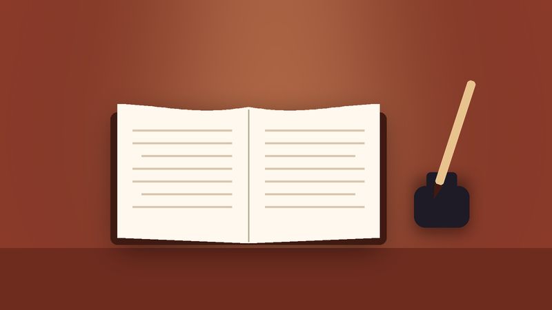 كتابٌ مفتوح ومحبرةٌ وقلمٌ على مكتبٍ أحمر